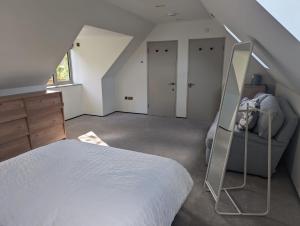 um quarto com uma cama branca e uma escada em The Nest at Fairfield em Wargrave