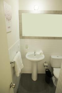 uma casa de banho branca com um lavatório e um WC em Slim HOTEL em Piura