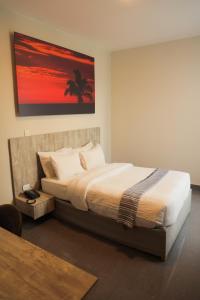 um quarto com uma cama com um quadro na parede em Slim HOTEL em Piura