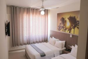 um quarto de hotel com duas camas e uma janela em Slim HOTEL em Piura