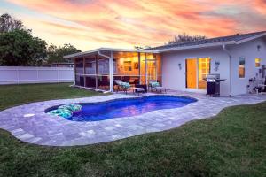a backyard with a swimming pool and a house at Seahorse Cottage - Pool Home in Naples