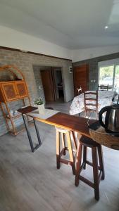 a living room with a wooden table and a bedroom at Casa en la Bota, Manantiales in Manantiales