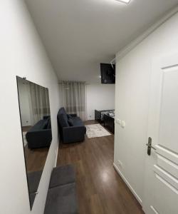 een woonkamer met een bank en een spiegel bij STUDIO proche du centre PARIS 15 min in Rosny-sous-Bois