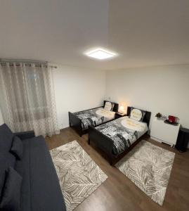 een woonkamer met 2 bedden en een bank bij STUDIO proche du centre PARIS 15 min in Rosny-sous-Bois