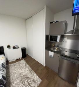 una pequeña cocina con fregadero y microondas en STUDIO proche du centre PARIS 15 min, en Rosny-sous-Bois
