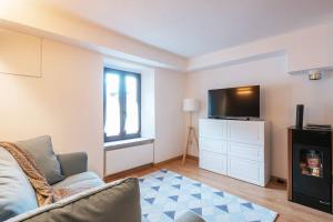 a living room with a couch and a flat screen tv at [IHost Luxury Flat Bormio] - Centrale 69 in Piatta