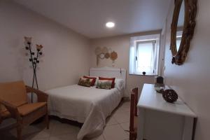 sypialnia z łóżkiem, krzesłem i oknem w obiekcie Casa de Carolina. w mieście A Coruña