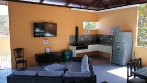a living room with a couch and a tv on the wall at Villa jr 4 by Villas Oasis Guacalillo in Tárcoles