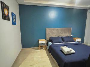 1 dormitorio azul con 1 cama con paredes azules en Luxury résidence Taj Nouaceur, en Nouaseur