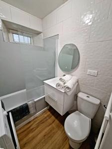 een witte badkamer met een toilet en een spiegel bij Appartement T2 Proche plage des Catalans in Marseille