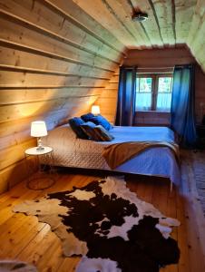 ObidowaにあるWidokowa Chataのログキャビン内のベッド1台が備わる客室です。