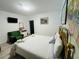 um quarto com uma cama grande e uma cadeira verde em CASA MATILI-1st floor of the house em Piatra Neamţ