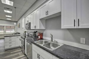 uma cozinha com armários brancos e um lavatório de aço inoxidável em The Pad-Spacious King apartment on main level em Albert Lea