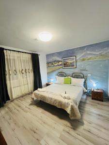 a bedroom with a bed with a painting on the wall at CASA MATILI-1st floor of the house in Piatra Neamţ