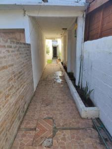un callejón vacío con una pared de ladrillo y un edificio en Acogedora Casa con Jardín, en Maldonado