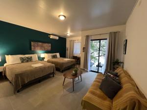 um quarto de hotel com duas camas e um sofá em Nativo em Santa Catalina