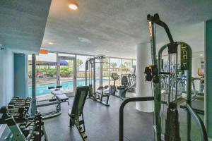 un gimnasio con máquinas de correr y una piscina en Pelican Beach Resort Unit 1109, en Destin