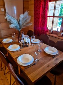 ObidowaにあるWidokowa Chataの皿とワイングラスが置かれた木製のテーブル