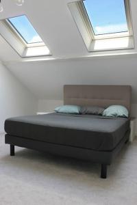 Ce lit se trouve dans un dortoir doté de 2 lucarnes. dans l'établissement Maison 85m2- 10min de Paris Centre - Ideal Olympics, à Houilles