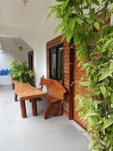 a wooden bench sitting in front of a building at Maui Homestay in General Luna