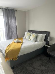 Un dormitorio con una cama grande con una manta amarilla. en Flat in umhlanga, en Durban