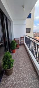 un balcón con 2 macetas en un edificio en Centro de la Ciudad - ¡a un paso de todo!, en Huancayo