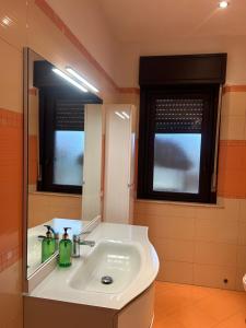 een badkamer met een witte wastafel en een spiegel bij Villa Sara on Etna in Pedara