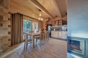 a kitchen and dining room with a table and chairs at Tatra Wood House Boutique in Zakopane