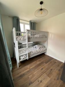 a white crib in a room with a window at Au clos du seltzbach in Hoffen