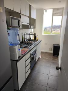 a kitchen with white cabinets and a stove top oven at Hermoso departamento in Coquimbo