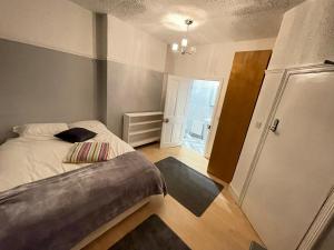 a small bedroom with a bed and a door at Room with private bathroom and shared kitchen in London