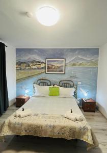 a bedroom with a large bed with a painting on the wall at CASA MATILI-1st floor of the house in Piatra Neamţ