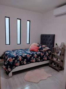 a bedroom with a bed with a floral comforter at Departamento en Heroica Matamoros in Matamoros