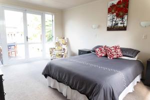 um quarto com uma cama com almofadas vermelhas em Kiwi bnb em Matamata