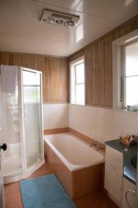 uma casa de banho com uma banheira e um lavatório em Kiwi bnb em Matamata