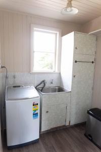 a kitchen with a sink and a refrigerator at Kiwi bnb in Matamata
