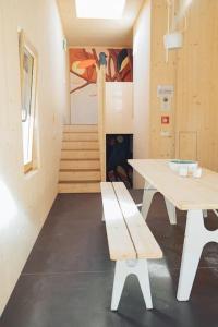 ein Zimmer mit einer Bank, einem Tisch und einer Treppe in der Unterkunft Gonner Haus in Rumelange