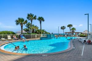 - une piscine dans un complexe avec des personnes dans l'eau dans l'établissement Pelican Beach Resort Unit 1109, à Destin