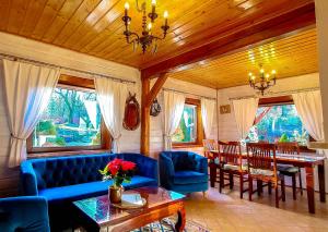 a living room with a blue couch and a table at Piaskowy Koń - Mountain Lodge & SPA- Karkonosze in Mniszków