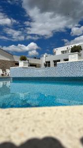 a swimming pool with blue water in front of a building at Hotel 376 in Villa Carlos Paz