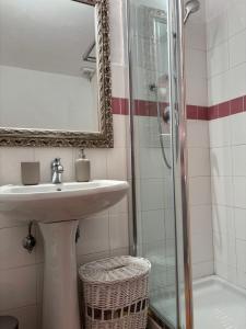 a bathroom with a sink and a shower with a mirror at White Love Versilia in Viareggio