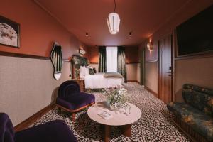 a hotel suite with a bed and a table at 1,75 Paris La Sève in Paris