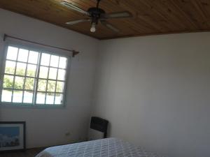 a bedroom with a ceiling fan and a bed at San Miguel del monte 6 personas con pileta in San Miguel del Monte +8 photos