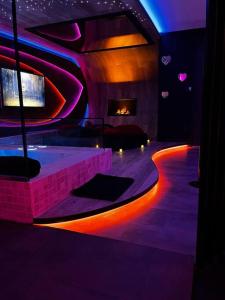 a room with a fireplace and a room with purple and blue lights at Les Secrets Rooms/Love Room in Rivesaltes