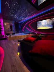 a room with a couch and a stage with purple lights at Les Secrets Rooms/Love Room in Rivesaltes
