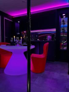 a bar with a pink lighting in a room at Les Secrets Rooms/Love Room in Rivesaltes