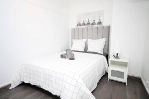 Dormitorio blanco con cama blanca y manta blanca en Magnifique Appart Cosy Tram 4pers Gare Wifi, en Pierrefitte-sur-Seine