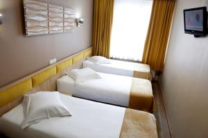 ブリュッセルにあるホテル ド フランスのベッド3台と窓が備わるホテルルームです。