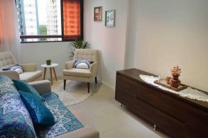 een woonkamer met een bank en een stoel bij Ap centro Convenções 3Q in Salvador