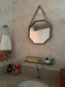 een badkamer met een wastafel en een spiegel aan de muur bij Ap centro Convenções 3Q in Salvador